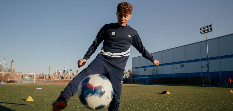 Studente atleta Yeswecollege con il pallone in un campo di calcio negli Stati Uniti